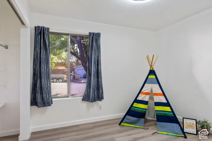 Recessed lighting, wood-finish flooring, and a built-in closet with shelving