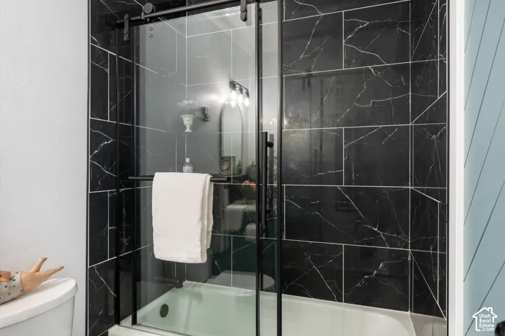Bathtub with black-framed glass sliding shower door