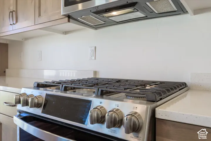 Stainless steel range with gas burners, complemented by a built-in microwave and range hood
