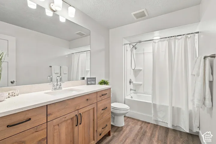 Expansive vanity with a light-toned countertop, dual-tone wood-finish cabinetry, and a full-width mirror