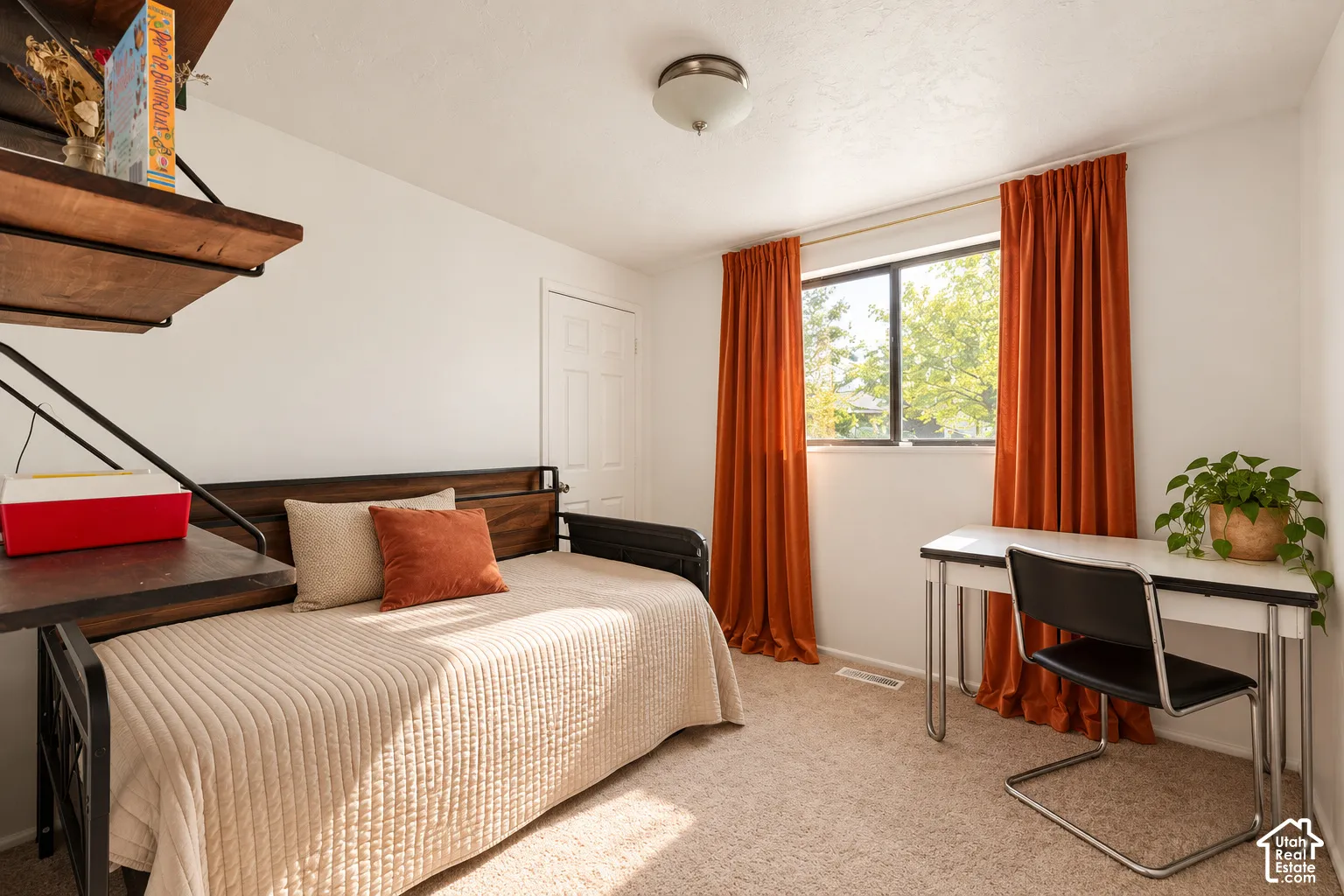 Built-in shelving, window with natural light, textured carpeting, and a flush-mount ceiling light fixture
