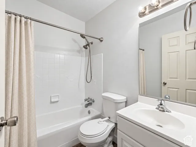White bathroom vanity with integrated sink, chrome faucet, and overhead bar lighting