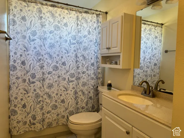 White vanity with a neutral-toned countertop and an integrated sink