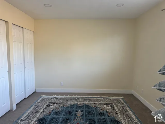 Recessed ceiling lighting, light-toned wall paint, carpet flooring, and white bi-fold closet doors
