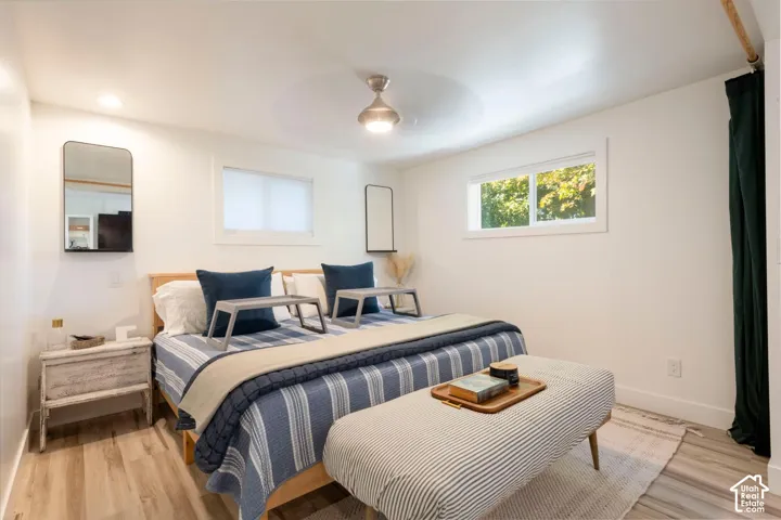 Recessed lighting, wood-finish flooring, white walls, and a ceiling fan with integrated lighting