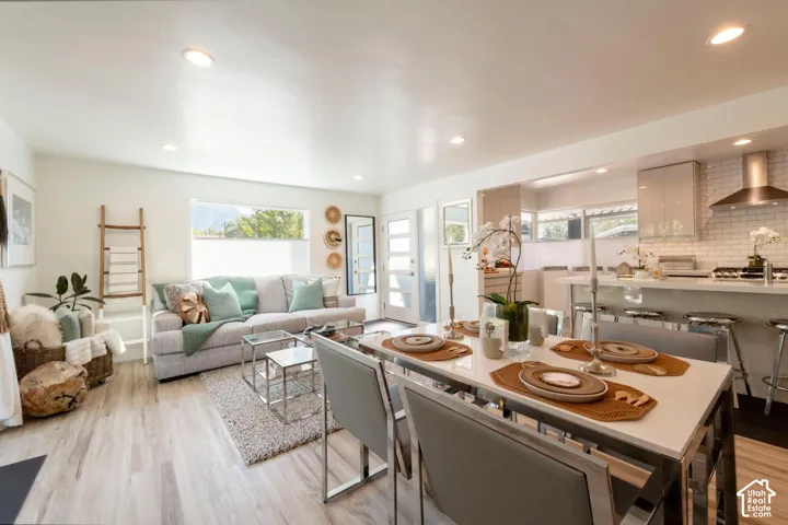 Open-concept living space featuring wood-finish flooring, recessed lighting, and a kitchen with white subway tile backsplash