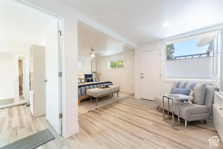 Wood-finish flooring throughout, white walls, recessed lighting, and a ceiling fan