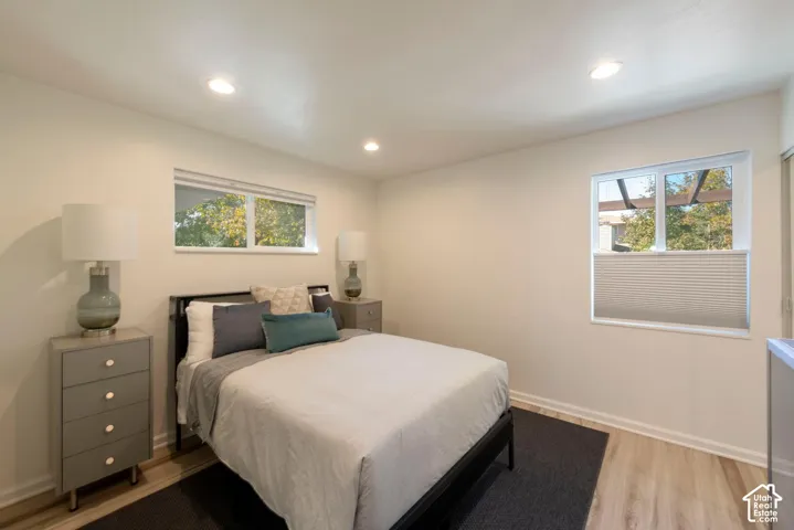 Recessed lighting, light-toned walls, multiple windows, wood-finish flooring, and white window blinds