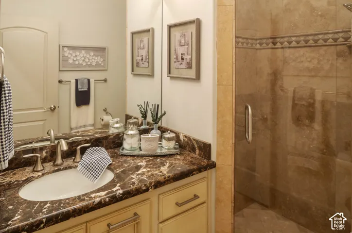 Vanity with a rich, dark countertop, single basin sink, and brushed nickel fixtures