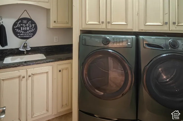 Built-in utility sink with a single-handle faucet, dark countertop, and cream-colored cabinetry