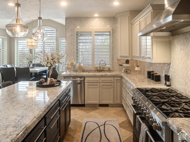 Gourmet kitchen featuring granite countertops, stainless steel appliances, a gas range, and a tiled backsplash