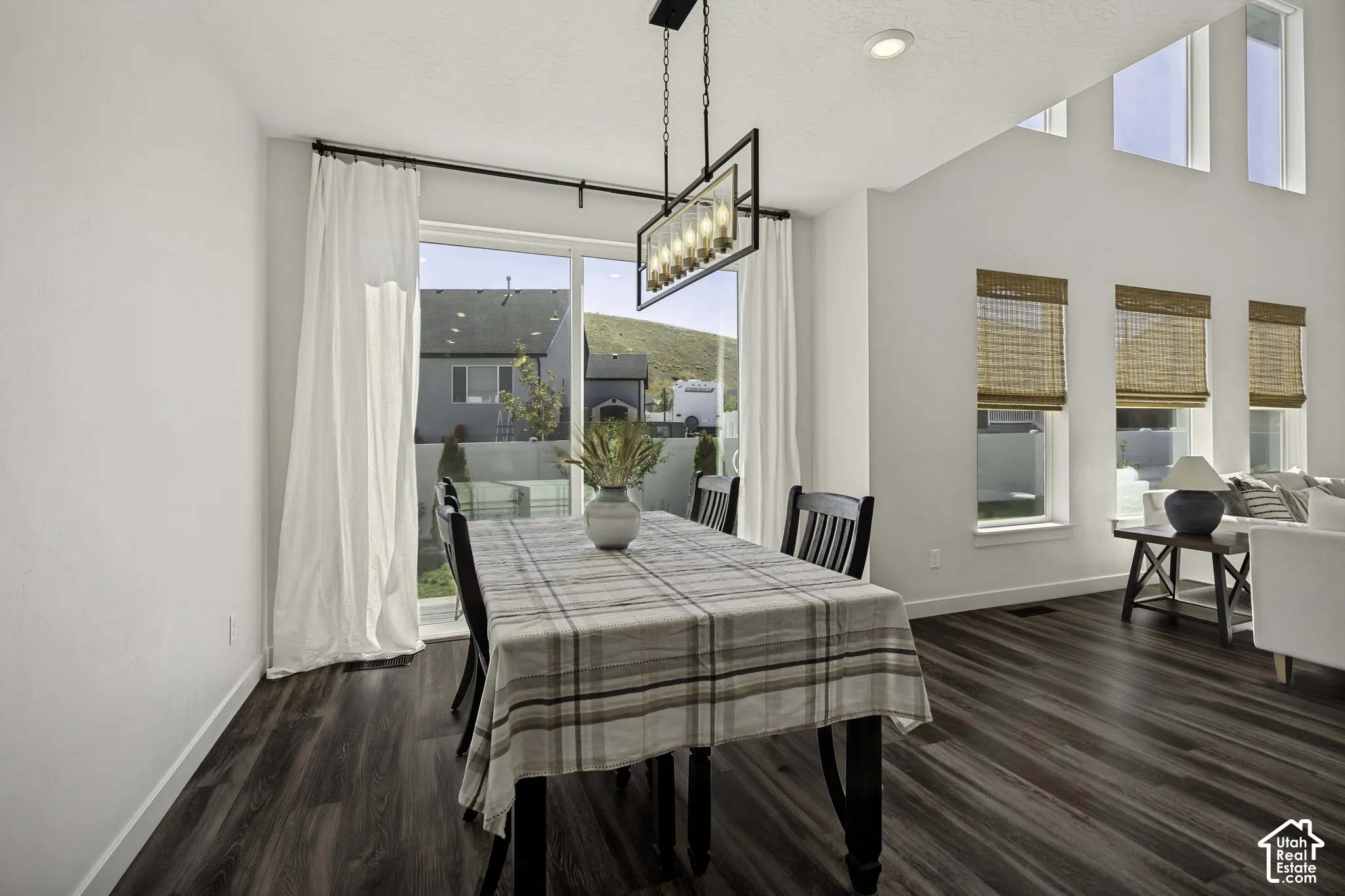Dining area featuring wood-finish flooring, vaulted ceilings, and a rectangular chandelier