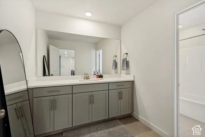 Expansive vanity with a countertop, integrated sink, and gray cabinetry