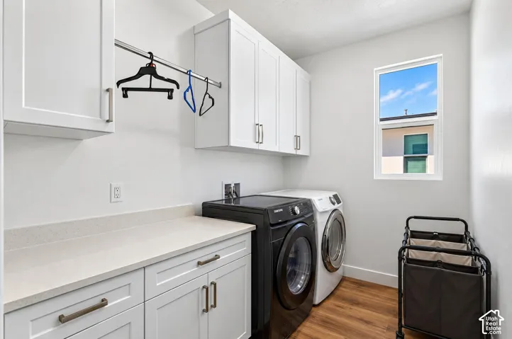White shaker cabinetry with brushed nickel hardware, light-toned countertop, wood-finish flooring, and a window providing natural illumination
