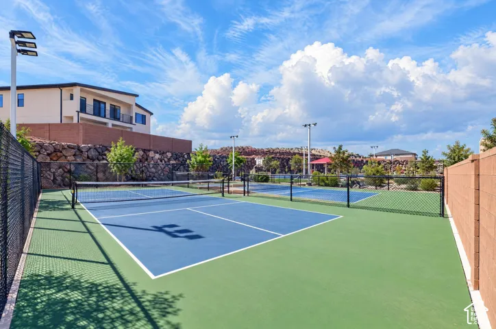 Multi-court recreation area featuring blue and green surfacing with white line markings, surrounded by black chain-link fencing