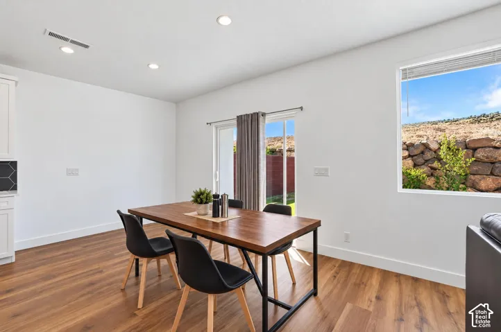 Wood-finish flooring, recessed lighting, white walls, and a sliding glass door