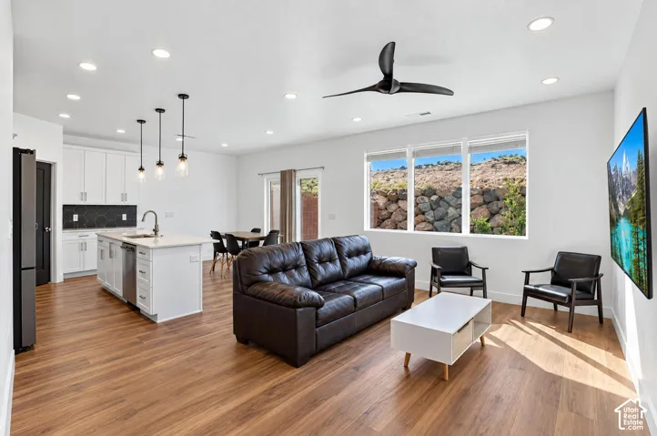 Open-concept living space with wood-finish flooring, recessed lighting, and a modern ceiling fan