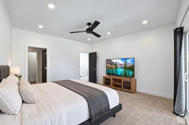 Carpeted room featuring a ceiling fan, recessed lighting, and a sliding glass door
