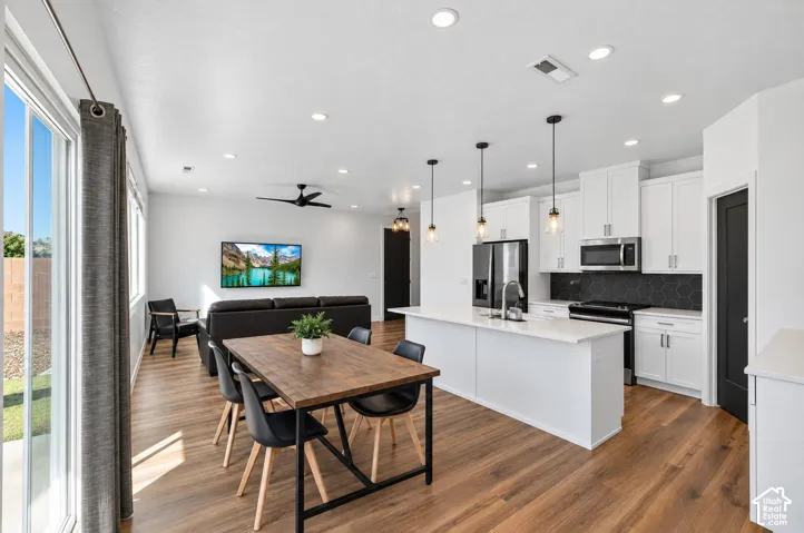 Open-concept living space with wood-finish flooring, recessed lighting, and a ceiling fan