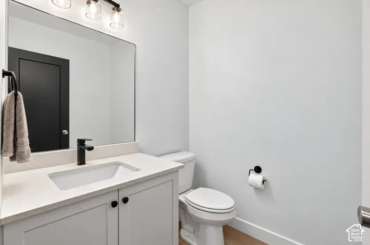 White vanity with a light-colored countertop, undermount sink, and matte black faucet