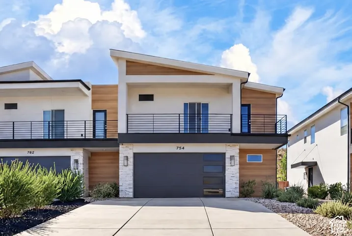 Modern exterior featuring light-toned stucco and wood-look siding accents