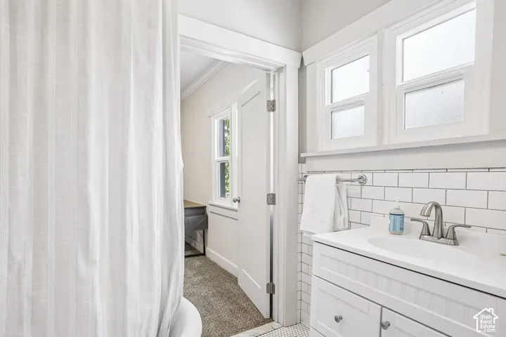 Vanity with integrated sink, subway tile backsplash, and dual pane windows