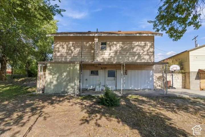 Two-story wood-sided exterior with a covered patio and a partially enclosed lower level