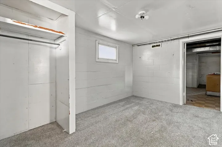 Carpeted room featuring a built-in closet with hanging rod and shelving