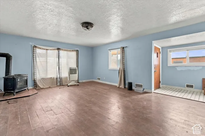 Wood-look flooring throughout, featuring a cast iron stove on a corner hearth