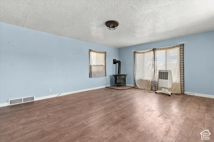 Wood-finish flooring, light blue painted walls, and a freestanding fireplace with a dark metal finish