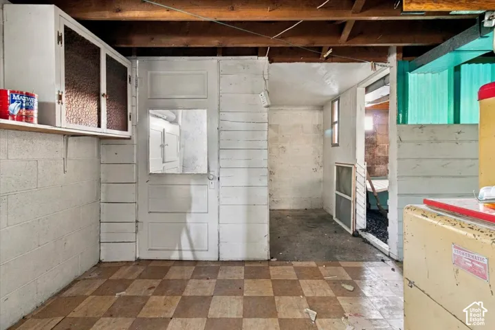 Checkered floor tiles, exposed ceiling joists, wall-mounted cabinetry