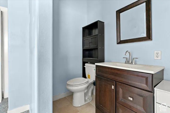 Bathroom with a dark wood-finish vanity, integrated sink, and brushed nickel faucet