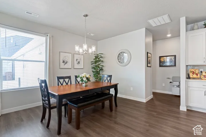 Wood-finish flooring, recessed lighting, and a modern chandelier