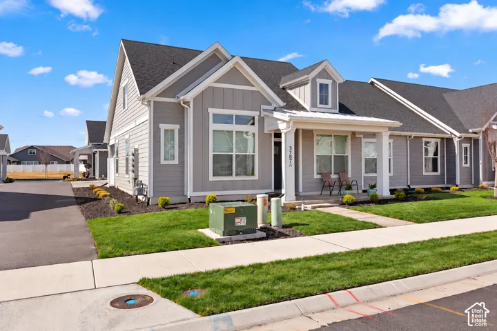 Contemporary-style exterior with board and batten siding accents, a covered front porch, and a dormer window