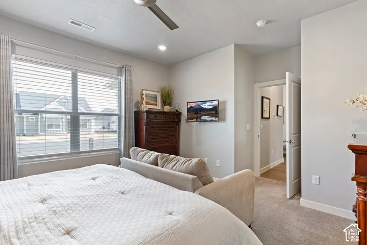 Recessed ceiling lights, ceiling fan, carpeting, and a window with blinds