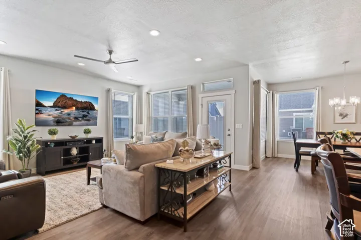 Recessed lighting, wood-finish flooring, ceiling fan, multiple windows with blinds, and a white door with a transom window