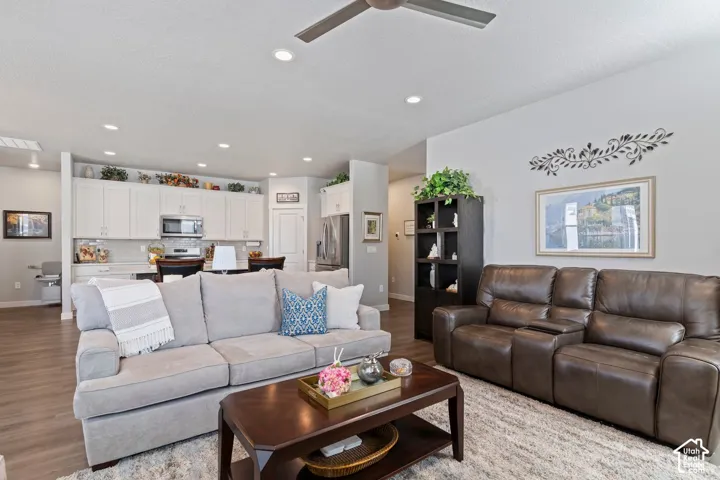 Open-concept living area with wood-finish flooring, recessed lighting, and a ceiling fan