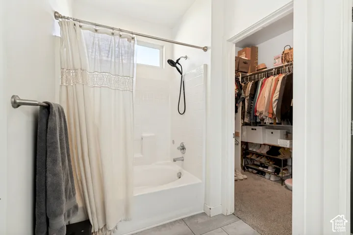 White tile shower surround, built-in bathtub, and an integrated shower shelf