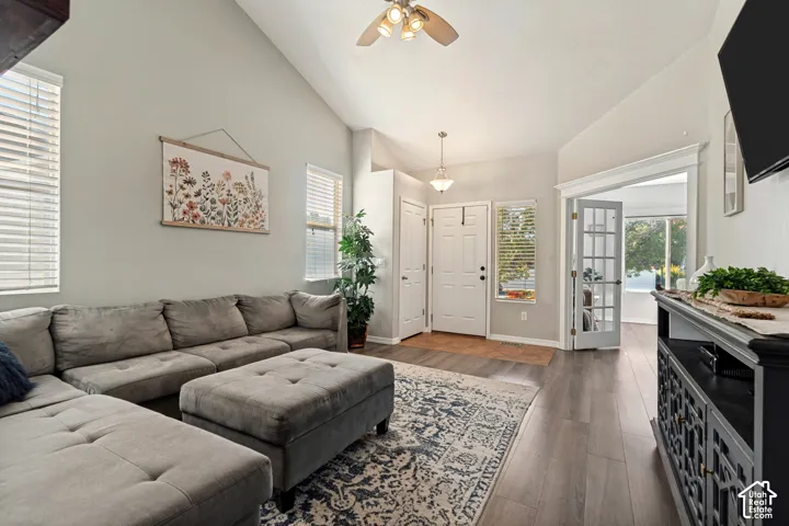 Vaulted ceiling, wood-finish flooring, white paneled doors, French doors, and a ceiling fan