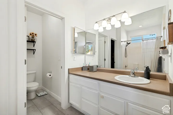 White vanity with multiple storage cabinets, an integrated sink, and an expansive mirror