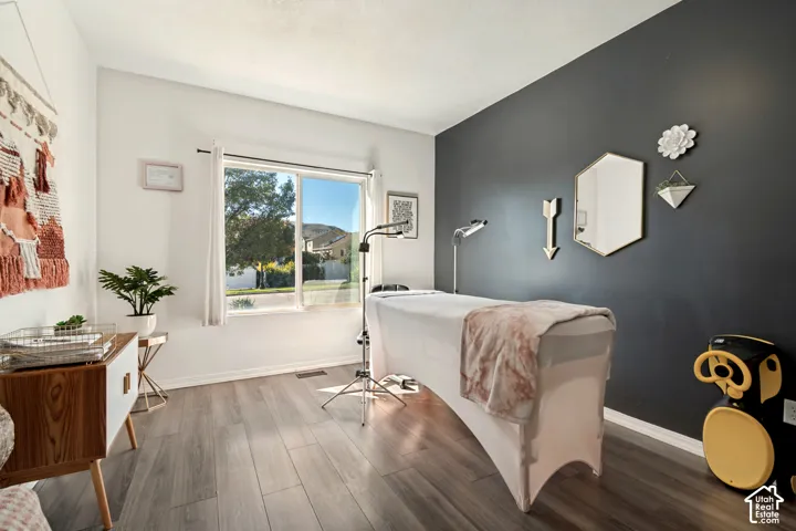 Wood-finish flooring, white walls, and a contrasting accent wall with a large window
