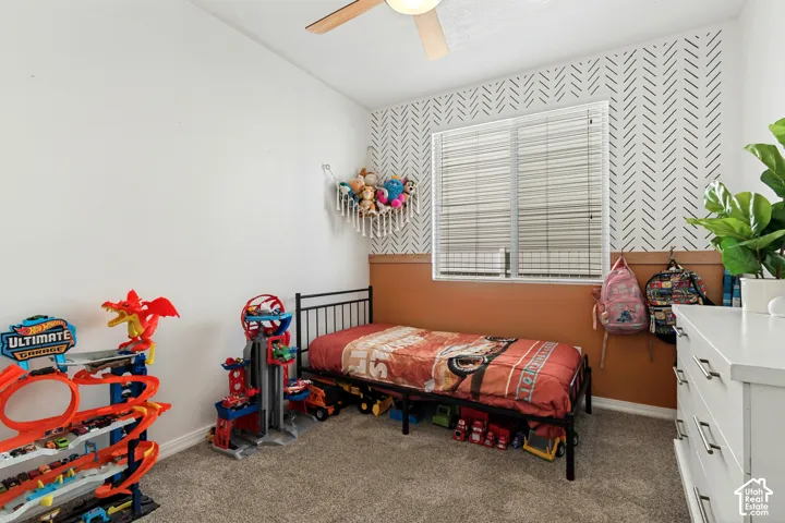 Window with blinds, ceiling fan, and carpeted flooring