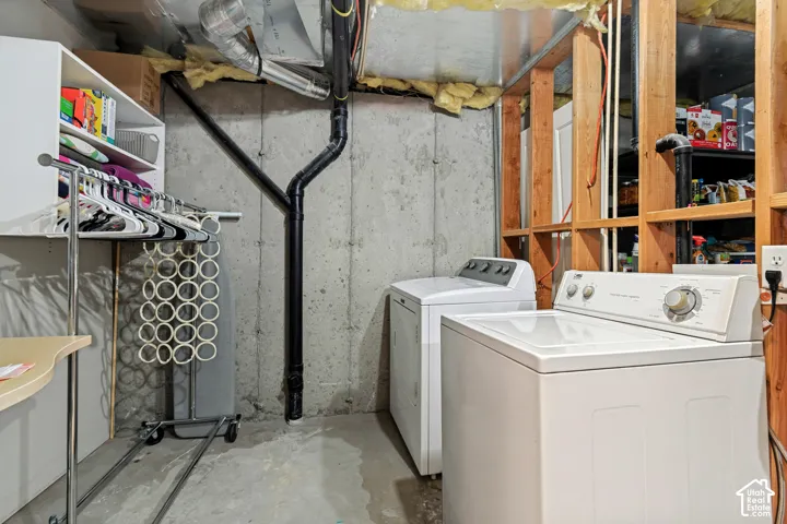 Laundry area with concrete walls and exposed wood framing