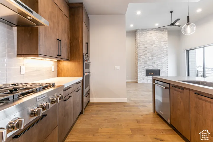 Kitchen featuring wood-finish cabinetry, stainless steel appliances, and under-cabinet lighting