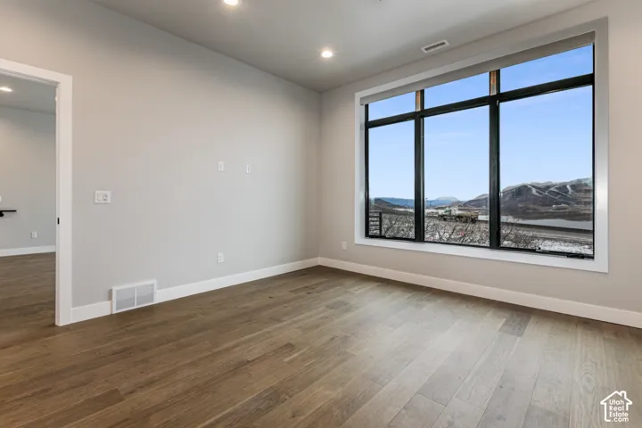 Hardwood-style flooring, expansive window, recessed lighting, and white trim