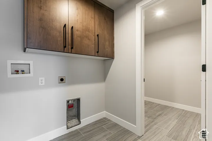 Wood-finish cabinetry with matte black hardware, light gray wall paint, and gray wood-look tile flooring