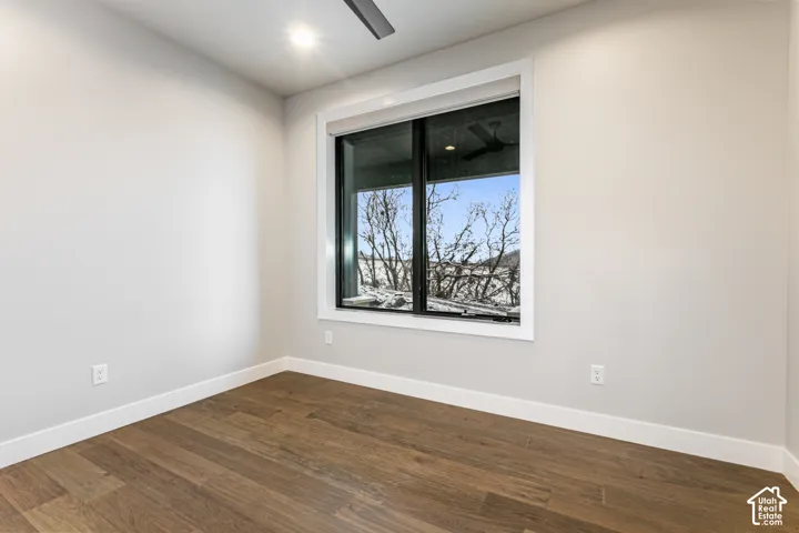 Recessed lighting, wood-finish flooring, and a large window with white trim