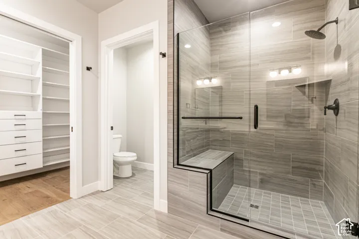 Glass-enclosed shower with a built-in bench and matte black fixtures
