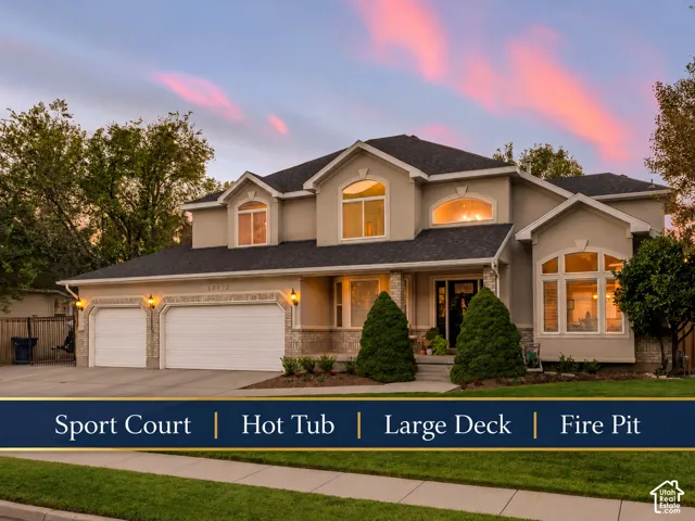 Stucco exterior with stone accents, arched windows, covered entry, and a three-car garage