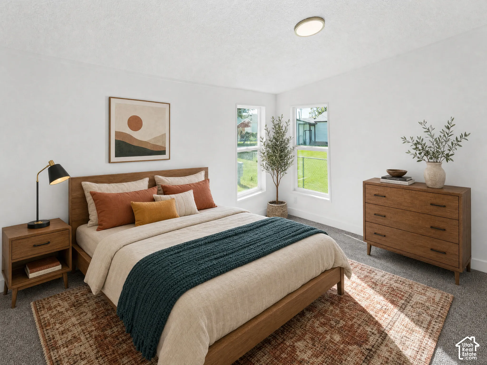 Plush gray carpeting, multiple windows providing ample natural light, and a modern flush-mount ceiling light fixture